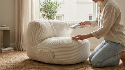 Femme qui brosse le tissu de son pouf blanc en velours côtelé petites côtés dans un salon bohème