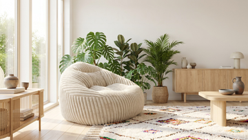 Grand pouf beige ergonomique en velours côtelé sur un tapis style marocain dans un salon moderne et épuré.